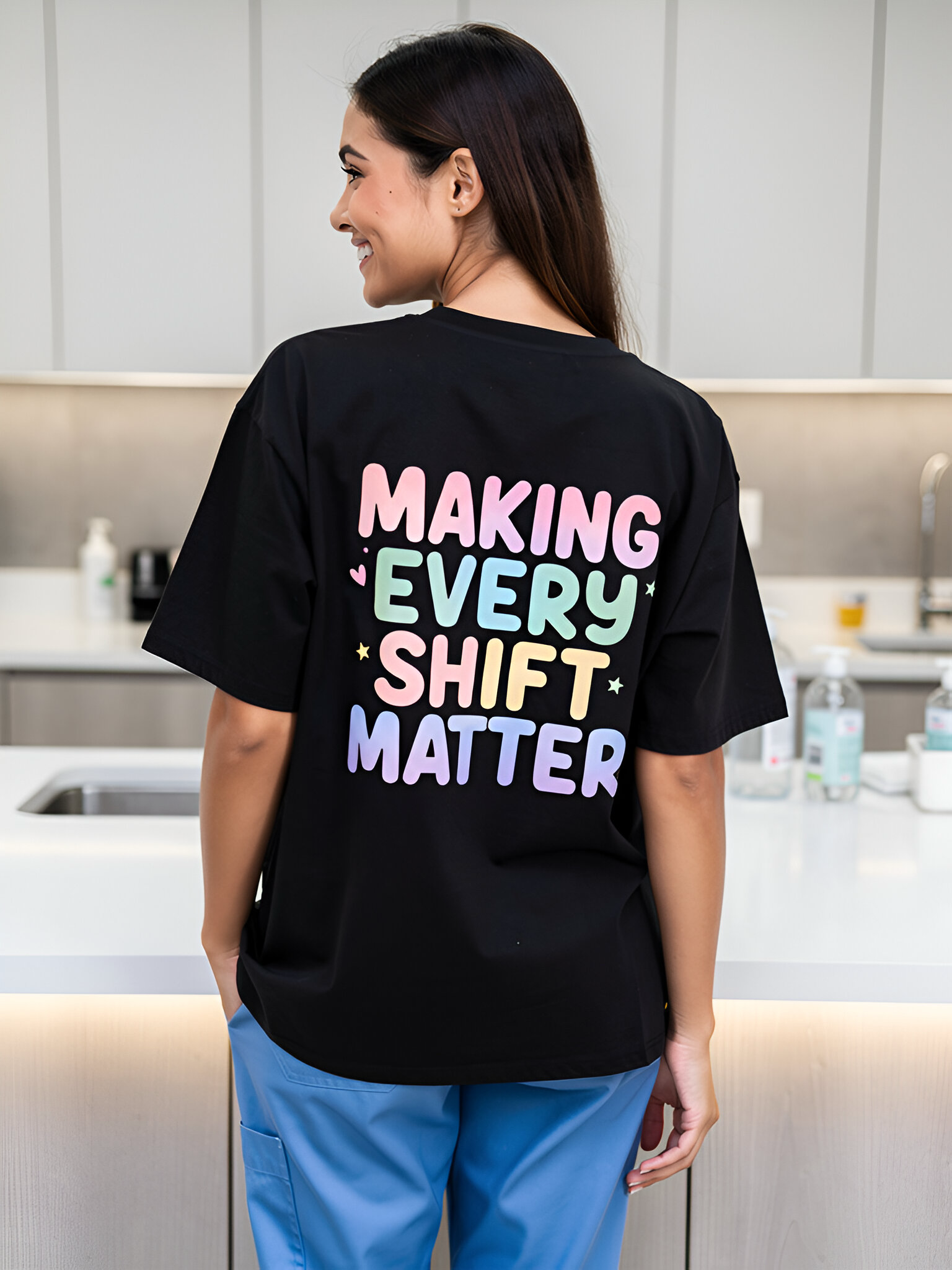 Person wearing a black t-shirt with colorful text in a kitchen
